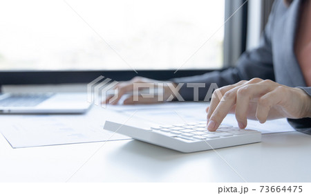 Accounting businesswomen are calculating income-expenditure and analyzing real estate investment data, Dedicated to the progress and growth of the company, Financial and tax systems concept. 73664475