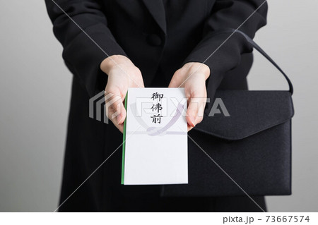 香典を渡す若い女性の手 【葬儀】 香典を渡す若い女性の手 【葬儀】 73667574