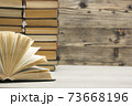Composition with vintage old hardback books, diary, fanned pages on wooden deck table and red background. Books stacking. Back to school. Copy Space. Education background. 73668196