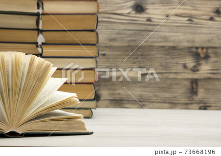 Composition with vintage old hardback books, diary, fanned pages on wooden deck table and red background. Books stacking. Back to school. Copy Space. Education background. Composition with vintage old hardback books, diary, fanned pages on wooden deck table and red background. Books stacking. Back to school. Copy Space. Education background. 73668196