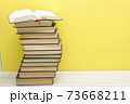 Composition with vintage old hardback books, diary, fanned pages on wooden deck table and red background. Books stacking. Back to school. Copy Space. Education background. 73668211