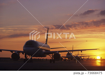 Planes Sitting on Tarmac at Sunset Planes Sitting on Tarmac at Sunset 73668475