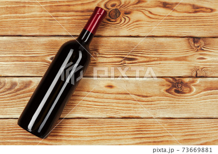 bottle of wine over wooden background. Close up. bottle of wine over wooden background. Close up. 73669881