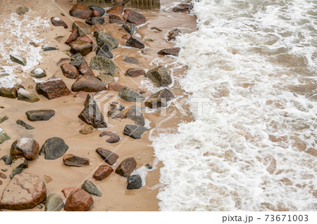 Large stones and sea waves on the beach Large stones and sea waves on the beach 73671003