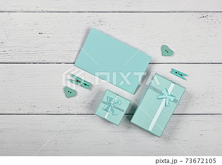 Teal gift boxes and paper note on white table 73672105