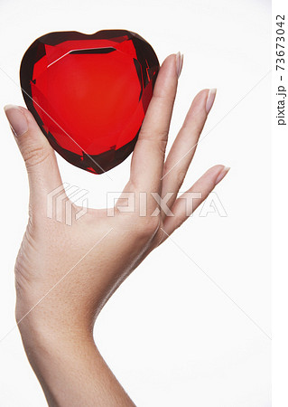 Closeup Of Hand Holding Up Heart Shaped Jewel 73673042