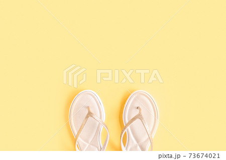 Women's summer traveler accessories sandals on yellow background. The concept of travel. Women's summer traveler accessories sandals on yellow background. The concept of travel. 73674021