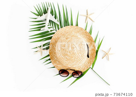 Traveler accessories concept on white background. Straw hat, model plane, airplane, sunglasses and tropical palm leaf. Summer background. Flat lay, Traveler accessories concept on white background. Straw hat, model plane, airplane, sunglasses and tropical palm leaf. Summer background. Flat lay, 73674110