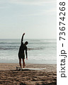 Surfer warming up. A person standing on a beach 73674268