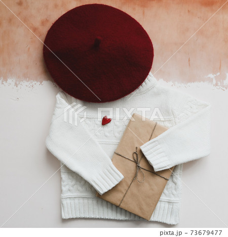Red heart, a gift and a white knitted sweater. Concept of preparing heart gifts. Love, romance, Valentines Day. Flat lay, top view, copy space Red heart, a gift and a white knitted sweater. Concept of preparing heart gifts. Love, romance, Valentines Day. Flat lay, top view, copy space 73679477