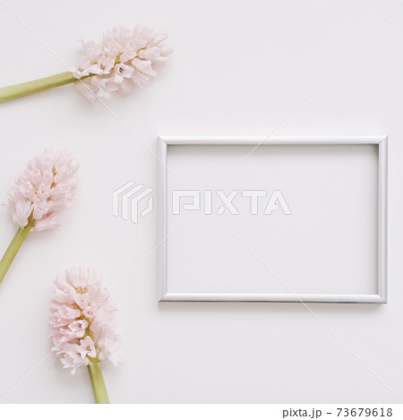 Wedding or birthday flat lay composition with pink flowers and blank photo frame, mockup, invitations. top view, copy space.  73679618