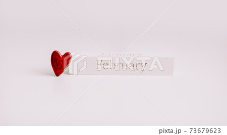 The word FEBRUARY on wooden cube and a red heart on white background. Love, romance, Valentines Day concept. Flat lay, copy space 73679623