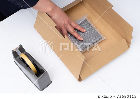 包作業をする女性の手元 73680115