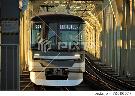 太陽のスポットライトを浴びる通勤電車。そして共に走る影 太陽のスポットライトを浴びる通勤電車。そして共に走る影 73680677