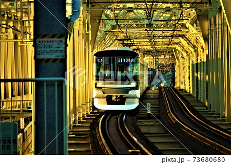太陽のスポットライトを浴びる通勤電車 そして共に走る影の写真素材 太陽のスポットライトを浴びる通勤電車 そして共に走る影の写真素材
