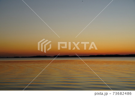 初春の茨城県　霞ヶ浦の夕焼け　黄昏時の風景　 73682486