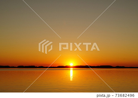 初春の茨城県　霞ヶ浦の夕陽　夕焼けの風景 73682496
