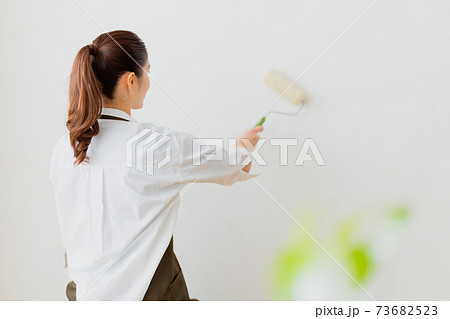 壁のペンキを塗る女性 73682523