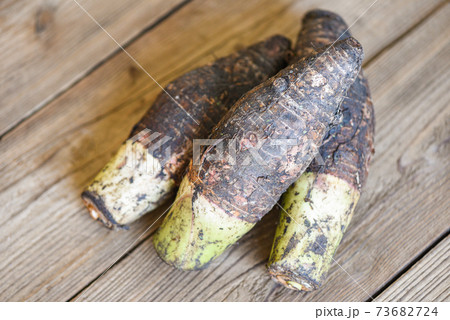 Taro root ready to cook, Raw organic brown taro on wooden table. Taro root ready to cook, Raw organic brown taro on wooden table. 73682724