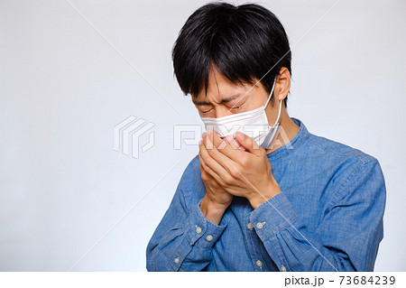 マスクをして咳をする男性　咳エチケット 73684239