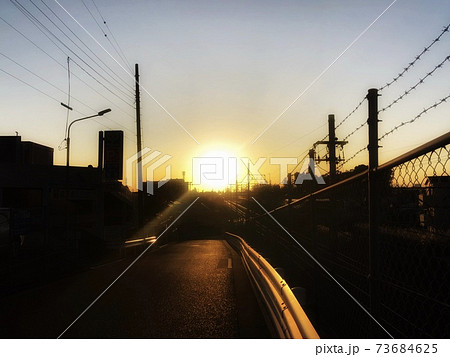 夕暮れの街並みのシルエットと街に沈む夕日のある風景の写真素材