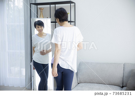 姿見でプロポーションをチェックする50代女性 姿見でプロポーションをチェックする50代女性 73685231