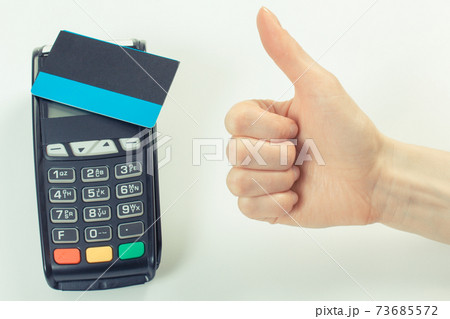 Hand showing thumbs up and payment terminal with contactless credit card 73685572