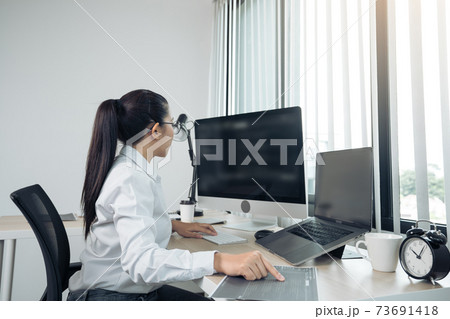 Software developers are analyzing about the code written into the program on the computer in office room. Software developers are analyzing about the code written into the program on the computer in office room. 73691418