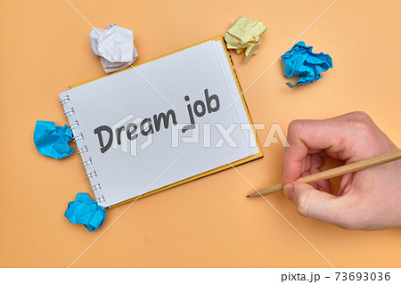 Hand lettering in a notebook of a dream job on an orange background. Hand lettering in a notebook of a dream job on an orange background. 73693036