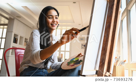 Young artist girl sitting and drawing at the modern art studio. 73693276