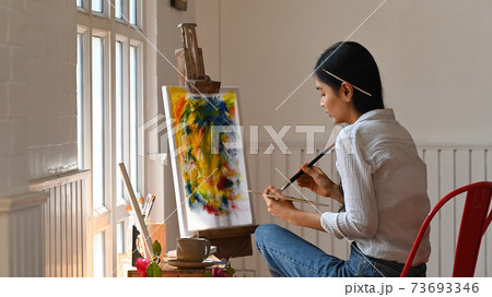 Young artist woman sitting and drawing watercolor at studio. 73693346