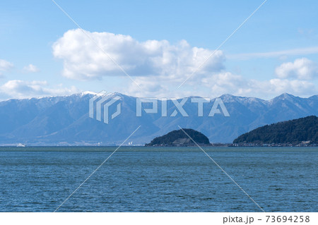 琵琶湖に浮かぶ沖島と雪景色の比良山系 琵琶湖に浮かぶ沖島と雪景色の比良山系 73694258