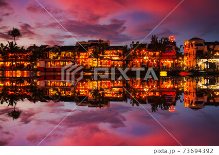 Traditional boats in front of ancient architecture in Hoi An, Vietnam. 73694392