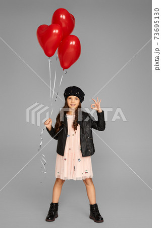 happy child girl holding red heart shaped balloon happy child girl holding red heart shaped balloon 73695130
