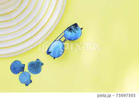Travel vacation background. Sun glasses sea shells yellow background. Concept summer holidays. 73697303