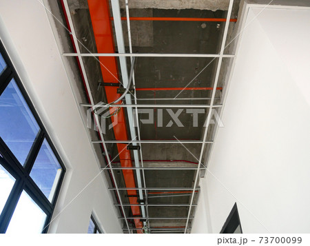 KUALA LUMPUR, MALAYSIA -JULY 24 2020: The suspended ceiling, electrical wiring, cabling and mechanical equipment under installation. It is hanging at the floor soffit. Cover by ceiling board. KUALA LUMPUR, MALAYSIA -JULY 24 2020: The suspended ceiling, electrical wiring, cabling and mechanical equipment under installation. It is hanging at the floor soffit. Cover by ceiling board. 73700099