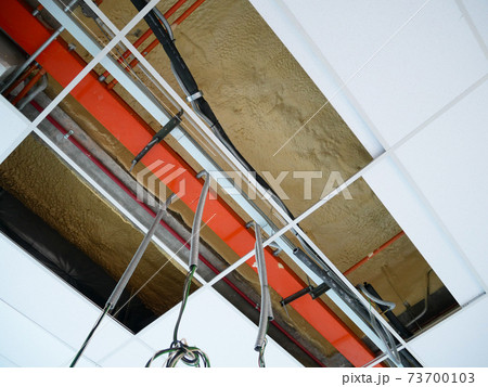 KUALA LUMPUR, MALAYSIA -JULY 24 2020: The suspended ceiling, electrical wiring, cabling and mechanical equipment under installation.  It is hanging at the floor soffit. Cover by ceiling board.  73700103