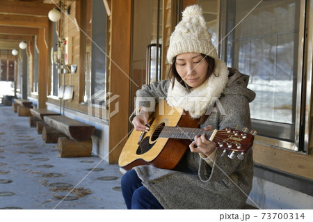 ギターを弾く女性 森や高原でギターを鳴らす趣味人の写真素材
