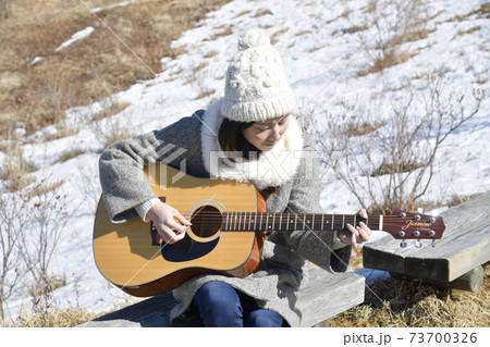 ギターを弾く女性 森や高原でギターを鳴らす趣味人の写真素材
