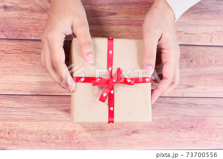 top view of women hand holding a gift box on table  73700556