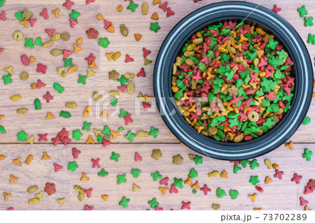 Cat food in bowl on wooden background 73702289