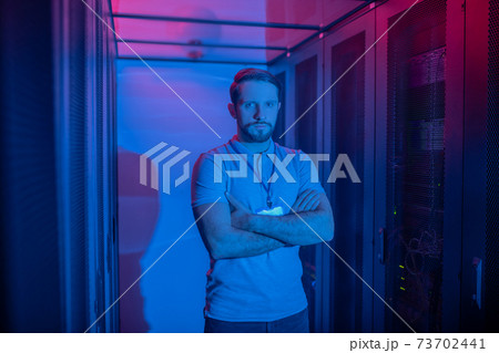 Calm man standing with folded arms on chest 73702441