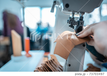 woman work with sewing machinery on shoe factory 73703497