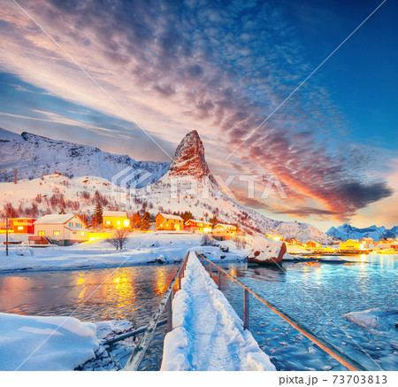 Amazing winter sunset view on Hammarskaftet Mountain Peak with footbridge above Gravdalbukta bay . Amazing winter sunset view on Hammarskaftet Mountain Peak with footbridge above Gravdalbukta bay . 73703813