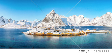 Aerial winter view on Sakrisoy village and snowy mountaines on background. 73704141