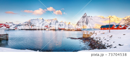 Fantastic winter view on Hamnoy village with port and  Olstinden peak on background. 73704538