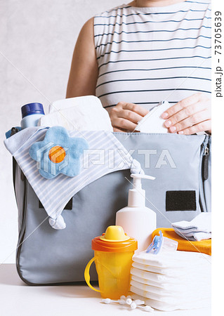 Woman packing diaper bag in maternity hospital. Woman packing diaper bag in maternity hospital. 73705639