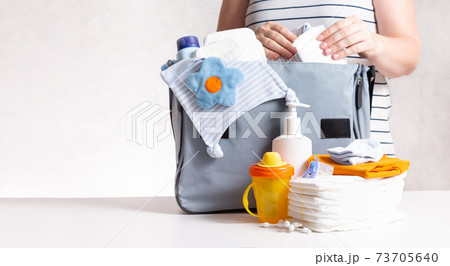Woman packing diaper bag in maternity hospital. Woman packing diaper bag in maternity hospital. 73705640