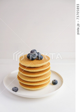 Freshly cooked soft delicious gluten free pancakes stacked on white plate. 73705893