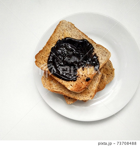 Delicious toasts with chocolate for breakfast before coffee, toasts on a white plate, dried bread on a white background. 73708488
